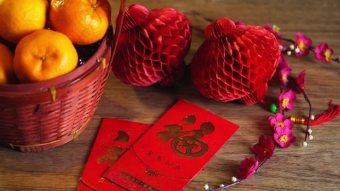 mandarin oranges, red lantern and chinese red envelope with males cheongsam on wood background. translation on red packet fu meaning blessing