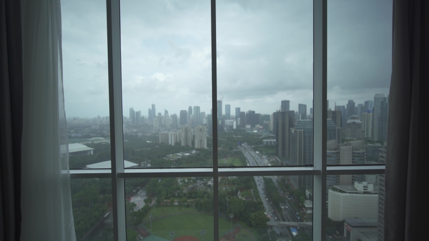 Jakarta, Indonesia - Modern Indonesian Capital City Cityscape Skyline with Tall Skyscrapers Buildings - Sudirman Road Central Business District - Man Looking Through Windows