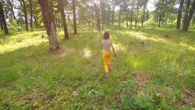 Slow motion. A teenage girl runs through a wild oak forest