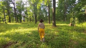 Teenage girl runs through a summer oak forest. Slow motion video. Middle zone of Russia