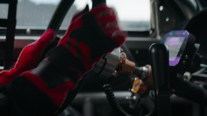 CU on hands and steering wheel, sports car driver in racing on a speedway. Fast speed, motorsport. Daytime shot. Shot with 2x anamorphic lens Royalty-Free Stock Footage #1066508899