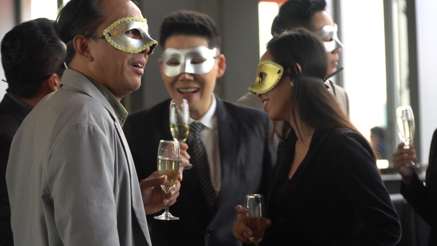Happy asian senior business man wearing masquerade mask enjoy  drinking wine and dancing having fun with colleague celebrating at dinner in Company party to anniversary | Shutterstock HD Video #1066511695