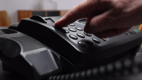 Men's Hand Dials On The Number Buttons On The Old Fax Telephone. A Man's Hand Picks Up The Phone And Dials A Phone Number On The Black Numpad Of A Landline In The Office..
