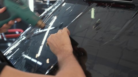 Car window tinting. Process of Installation window tint in Car Detailing Studio Garage by professional detailer