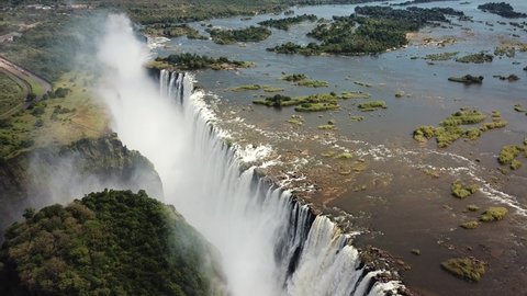 The Victoria Falls at the Border of Zimbabwe and Zambia in Africa. The Great Victoria Falls One of the Most Beautiful Wonders of the World. uUnesco World Heritage. Aerial Shot. Camera Moves Down