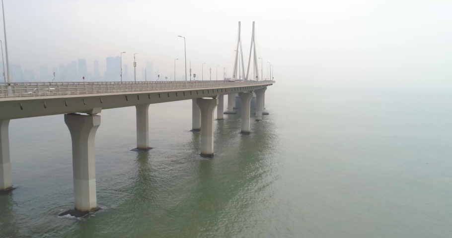 A drone shot at Bandra Worli Sea Link seen from an aerial view in slow motion. Cinematic drone movement with the iconic Mumbai Sea Link at the forefront and the city view in the background. Royalty-Free Stock Footage #1066534165