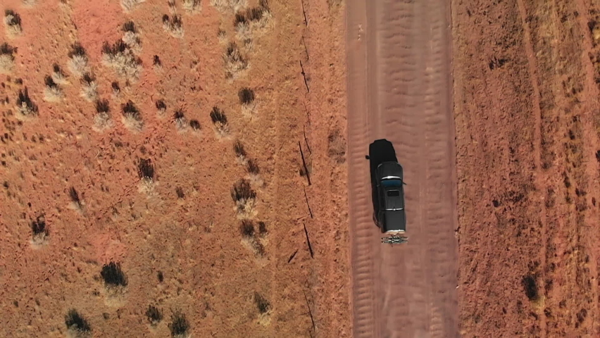 Aerial Top Down of Black Truck Overtaking Silver Station Wagon on Dirt Road