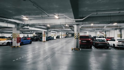 Underground parking with cars, time lapse. Underground parking with quickly cars coming. Many cars in parking garage. An underground parking garage filled with vehicles.