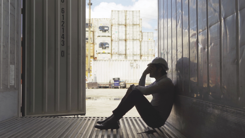 A fired man. Stressed upset depressed worried disappointed worker working in cargo container warehouse industry factory site in export, import, and transportation concept. Business people. Royalty-Free Stock Footage #1066549471