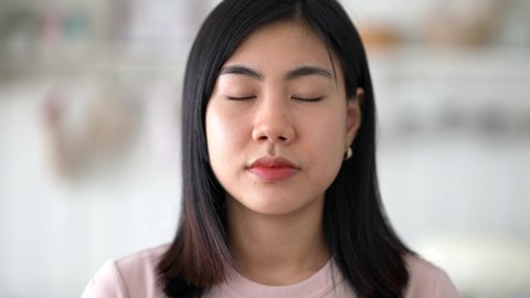 Close-up of beautiful young asian women face looking at the camera confidently. Portrait of a beautiful asian girl with a confidently and serious face.