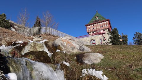 St. Moritz, Switzerland - November 26, 2020: St. Moritz with its lake is a high Alpine resort town in the Engadine in Switzerland. A stream below the famous Palace Hotel in St.Moritz
