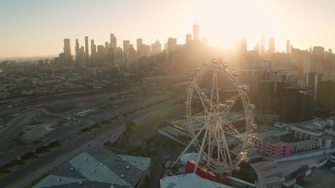 Melbourne, Australia - Jan 24, 2021: Aerial video of Ferris wheel and Melbourne CBD at sunrise