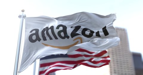Seattle, WA, USA, January 28, 2021: flag with the Amazon logo waving in the wind with the American flag in the background. Amazon is an American multinational technology company based in Seattle