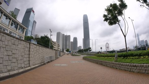 Dolly Shot to Business Buildings and Ferris Wheel in Hong Kong, China. Pedestrian Sidewalk Near the Embankment. Urban Scene. Empty asia. Pandemic Situation. Lockdown. Nobody in the street