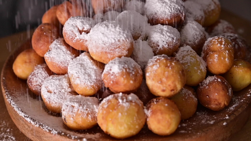 Baked castagnole with powdered sugar. Street food, round biscuits with sugar for the carnival of Venice. Traditional sweet pastries during the carnival period in italy. Copy space.  Royalty-Free Stock Footage #1066568020