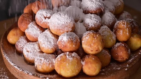 Baked castagnole with powdered sugar. Street food, round biscuits with sugar for the carnival of Venice. Traditional sweet pastries during the carnival period in italy. Copy space. 