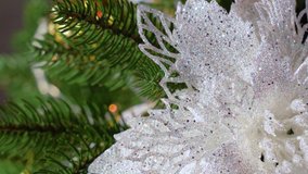 Closeup view 4k video of green Christmas tree decorated with beautiful bright holiday ornaments. Shiny sparkling white flower and green pine or fir branches of holiday traditional tree - Powered by Shutterstock - Get 15% off with code: PIKWIZARD15