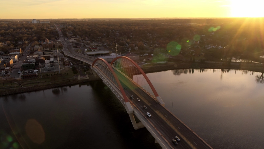 Orbiting aerial view of Hastings Bridge over Mississippi River, as the sun hits the distant horizon