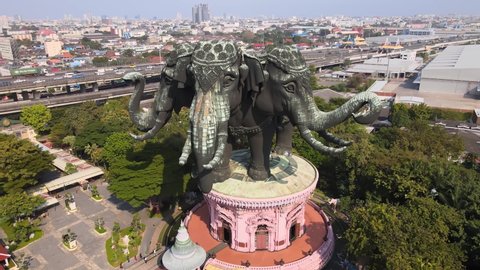 4k Cinematic Aerial footage of Erawan museum in Samut Prakan Province, Bangkok, Thailand. Drone pans backwards at a three-headed elephant statue. Hindu gods. Ganesha. Megapolis Cityscape