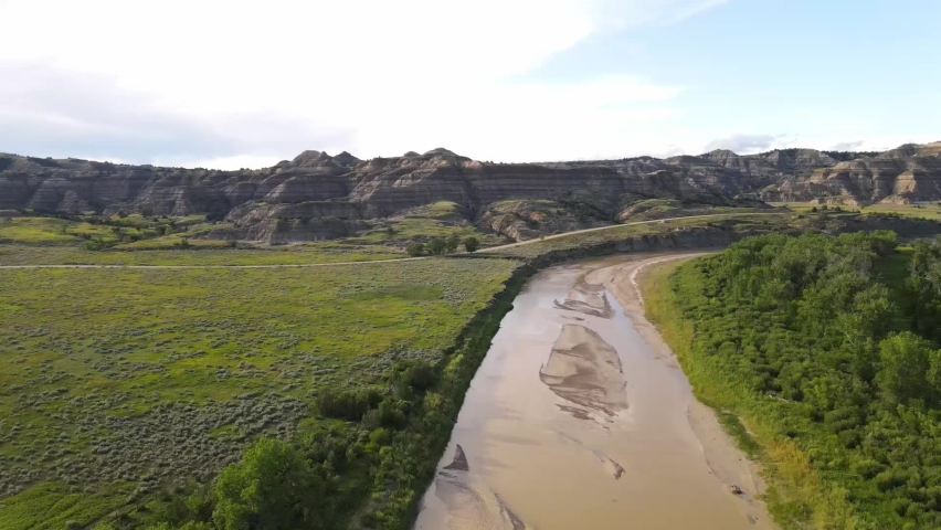 Panning view of the Little Missouri River with views of Theodore Roosevelt National Park right across the river in North Dakota on a summer day