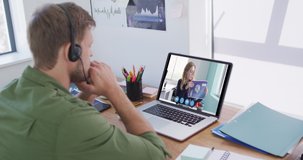 Caucasian man using laptop and phone headset on video call with female colleague. staying at home in self isolation during quarantine lockdown.