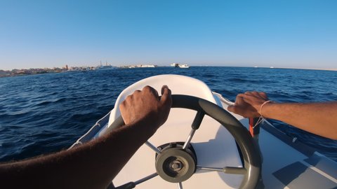 Man is driving the yacht at sunset. Pov