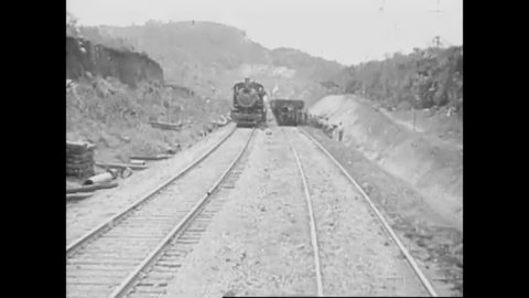 CIRCA 1910s - A locomotive hauls a dirt train of rail cars during the construction of the Panama Canal in 1912.