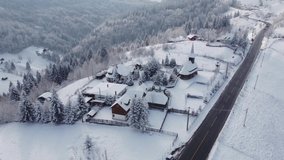 Aerial view of winter landscape above the Transylvanian village, Fundata, on Rucar-Bran pass. Aerial footage in the Carpathian Mountains
