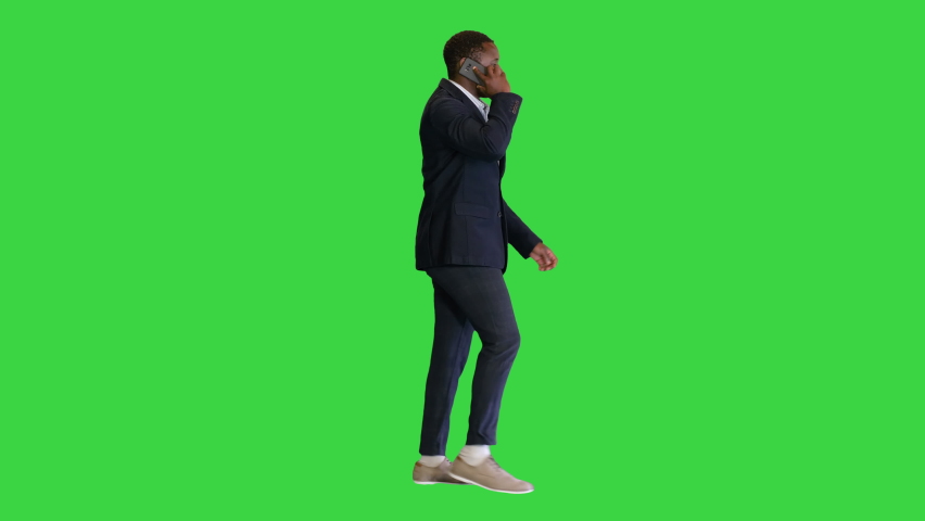 Happy African American man walking and talking on the phone on a Green Screen, Chroma Key.