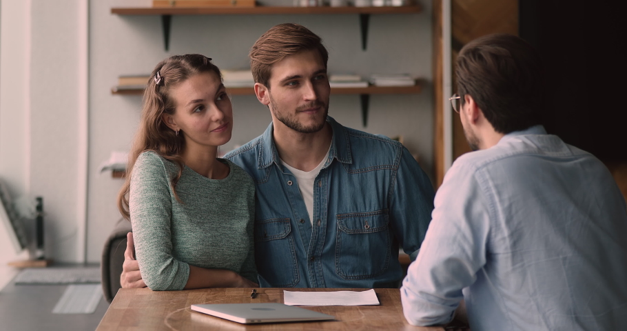 Happy loving family couple discussing apartment purchase with professional real estate agent at office meeting, signing paper contract, getting keys from own accommodation, celebrating successful deal | Shutterstock HD Video #1066586338