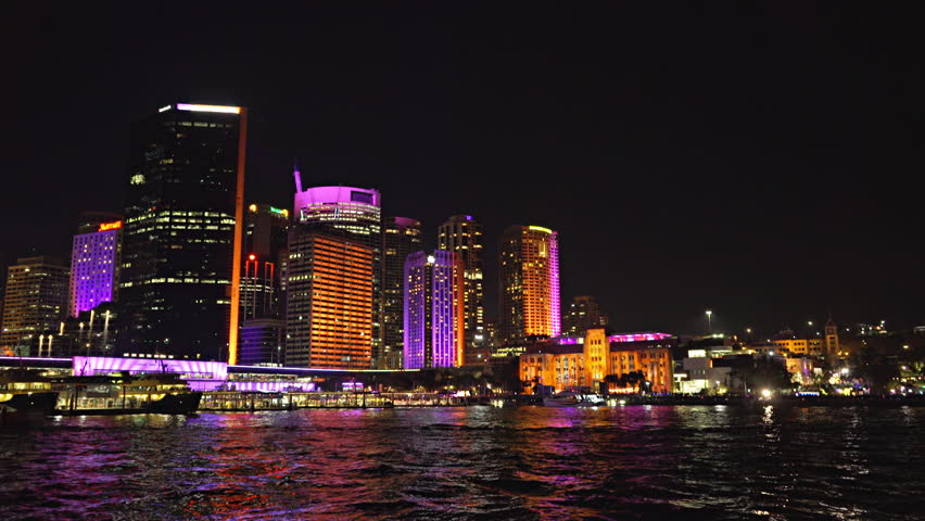wide shot of office buildings and circular quay in sydney brightly lit up during the vivid festival 2015