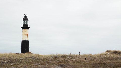 Tourists walking Towards the Cape Pembroke Lighthouse, Falkland Islands (Islas Malvinas).  