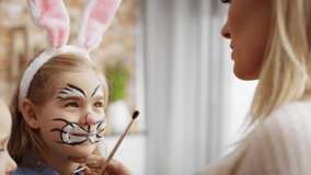 Video of mom painting Easter bunny on her daughter's face. Shot with RED helium camera in 8K