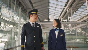 Asian airliner pilot and air hostess walking and talking together in airport terminal to the airplane with smile face and happiness. Commercial cabin crew or hostress and pilot occupation concepts. - Powered by Shutterstock - Get 15% off with code: PIKWIZARD15