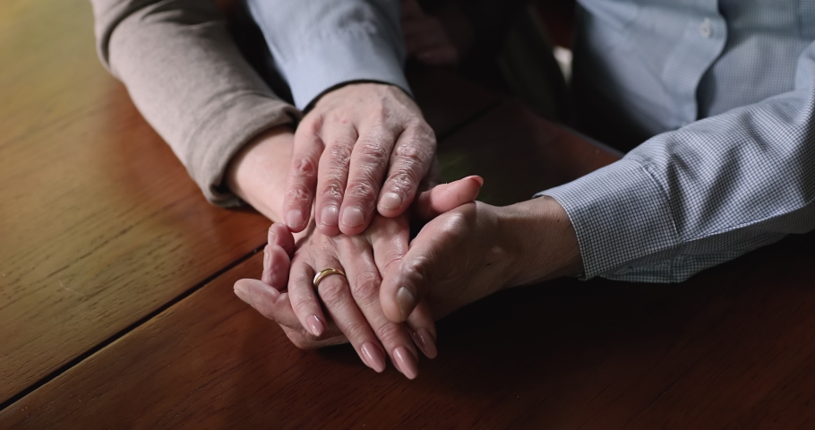 Close up elderly husband stroking wrinkled hand or mature wife, showing love and care, supporting in difficult life situation, holding sincere conversation or enjoying affectionate moment at home. | Shutterstock HD Video #1066624285