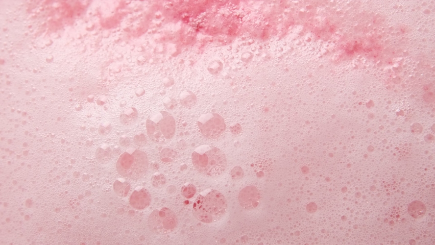 Texture of pink soap foam seethes boil with bubbles abstract background.