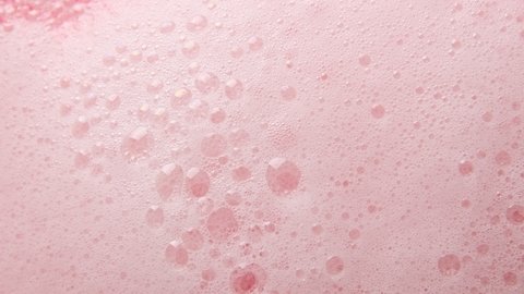 Texture of pink soap foam seethes boil with bubbles abstract background.