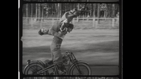 1940s Indianapolis, IN. Two Men Perform Dangerous Stunt on Motorcycle. The Daredevil Rides Upside Down with No Hands at Fast Speed. 4K Overscan of Vintage Archival 16mm Film Print. 