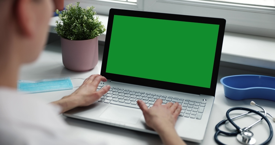 doctor working on laptop in clinic office. computer with green screen mockup  Royalty-Free Stock Footage #1066637881