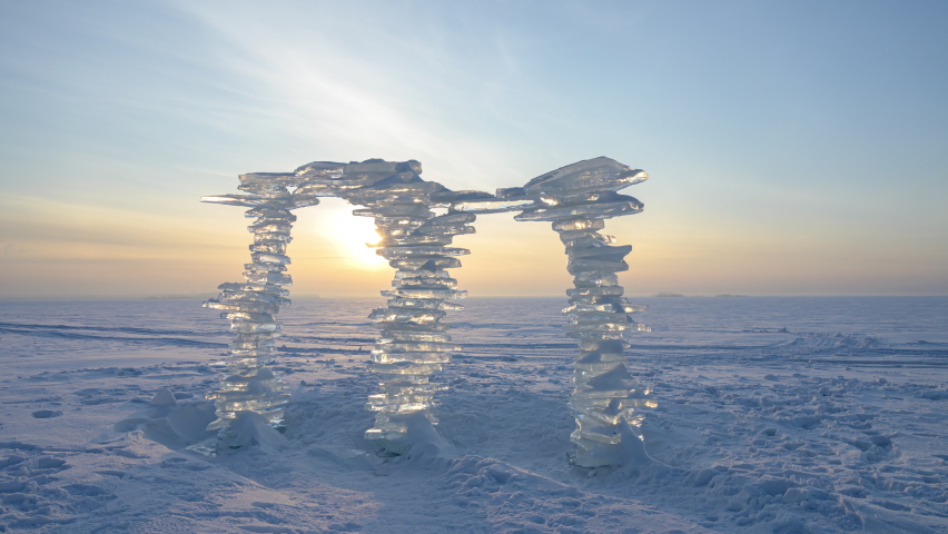 A sculpture made of pieces of ice against the backdrop of a sunset, on the shore. Royalty-Free Stock Footage #1066637950