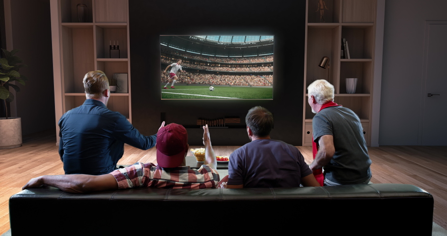 A group of fans are watching a soccer on TV and celebrating victory sitting on the sofa in the living room. The room is made in 3d. Royalty-Free Stock Footage #1066638049