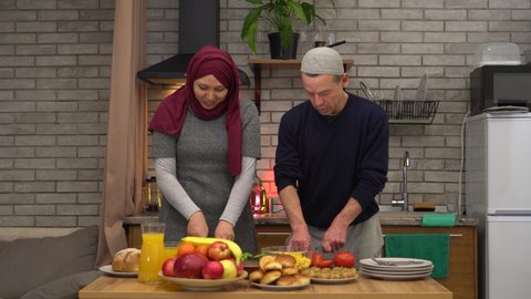 Authentic muslim husband and wife cooking together at home. Middle-aged happy arabic couple in love preparing food in a kitchen. Fasting During Ramadan and Halal Food