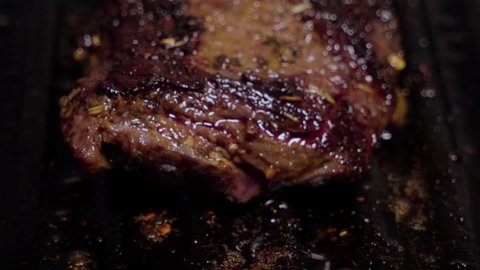 Tilt Up, Delicious steak cooks on cast iron grill, Closeup Selective Focus