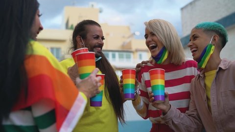 Happy people with different age cheering and drinking cocktails in gay pride festival during corona virus outbreak