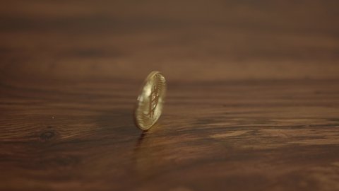 Bitcoin gold coin spins on wooden table,  Bitcoin mining concept 