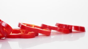 Sliced red bell pepper rings on a white background falling in slow motion. Slices of ripe pepper are falling on a white background.  - Powered by Shutterstock - Get 15% off with code: PIKWIZARD15