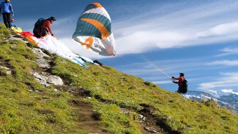Chli Aubrig, Switzerland - October 31, 2020: Paraglider starting from top of Chli Aubrig peak close to Einsiedeln in canton of Schwyz, Switzerland during autumn 2020