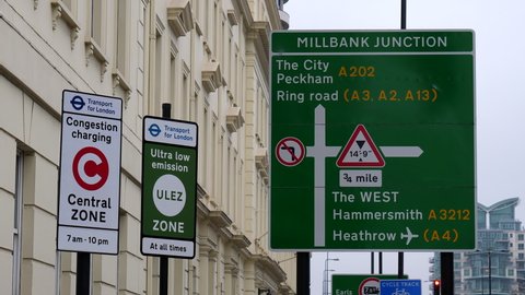 LONDON, ENGLAND, UNITED KINGDOM - CIRCA NOVEMBER, 2020: Red bus passing congestion charging zone sign in London on Vauxhall Bridge Road; handheld camera.