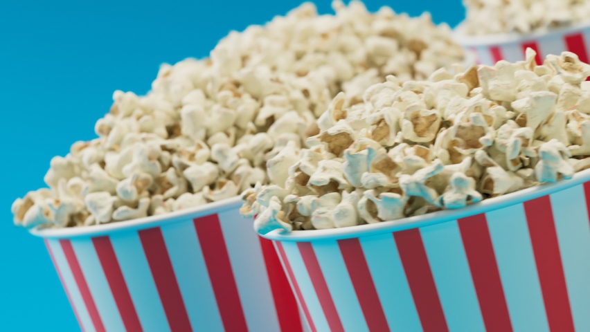 Seamless looping animation of a set of full red and white striped popcorn buckets. Boxes are spinning around. Fast-food snacks. Salty snacks ready to eat while watching a movie at the cinema or show.