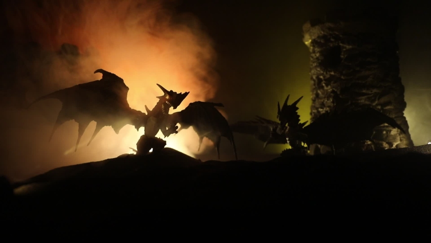 Fantasy battle scene with dragons attacking a medieval castle at night. Battle between dragon and heroic soldiers. Creative table decoration. Selective focus